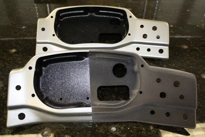 Two metal brackets shown side by side, the top is silver with multiple holes, while the bottom has a half black matte coating, showcasing a finish comparison.